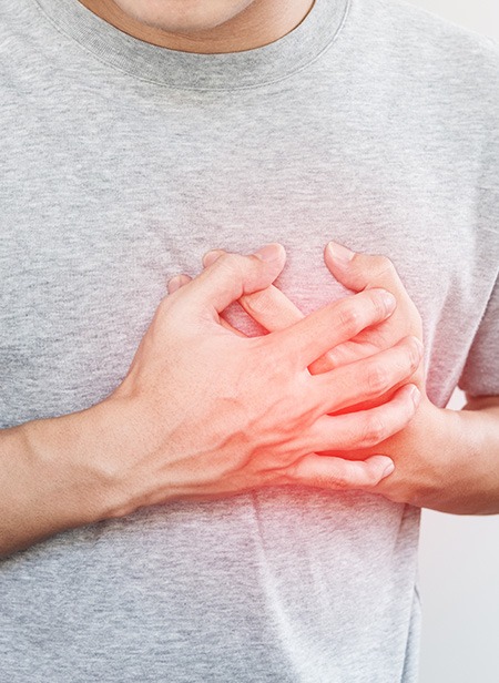 Man in gray t-shirt experiencing heart problems